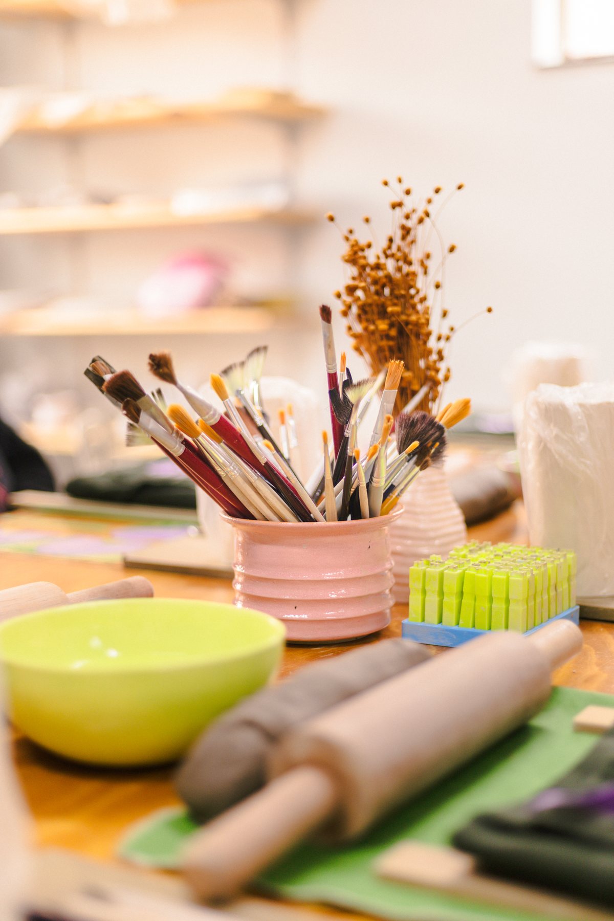 Materiais da Lumbre: pincéis, rolo, argila e bowl sobre a mesa do workshop